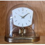 A mid 20th century Koma anniversary mantel clock, brass case with glass dome, the movement stamped