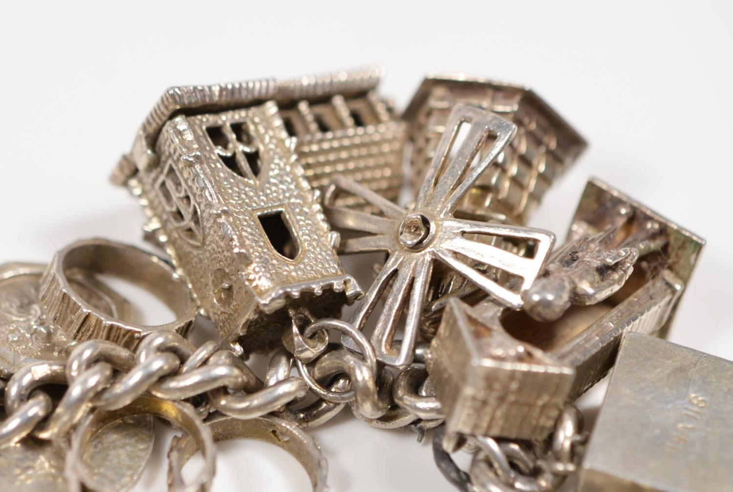 A silver charm bracelet, including a steam engine and hinged church, 103gm - Image 2 of 2