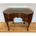 A mahogany kidney shaped desk, having crossbanded edge top above a centre drawer flanked either side