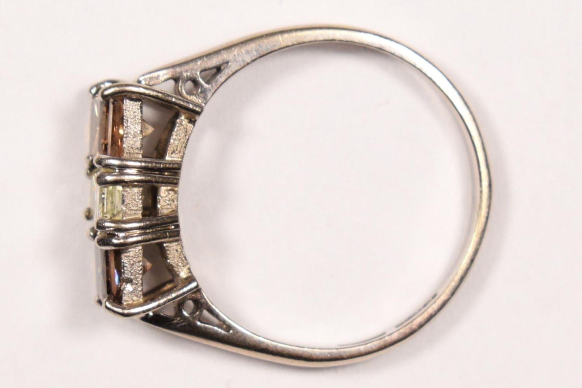 An 18ct white gold three stone diamond ring ring, claw set with a yellow stone of approximately 0. - Image 3 of 3