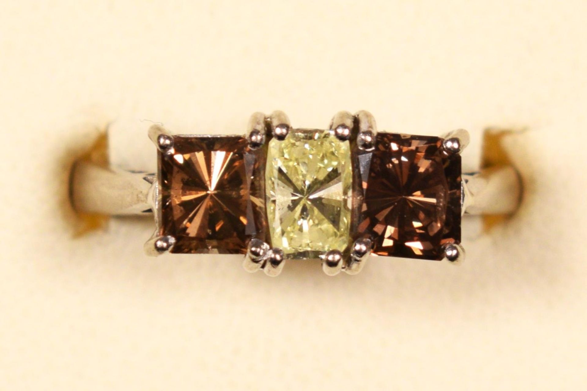 An 18ct white gold three stone diamond ring ring, claw set with a yellow stone of approximately 0. - Image 2 of 3