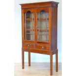 An Edwardian mahogany cabinet/bookcase, the twin glazed doors opening to reveal two adjustable