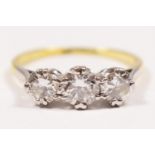 An 18ct gold three stone diamond ring, claw set with graduated brilliant cut stones, approximately