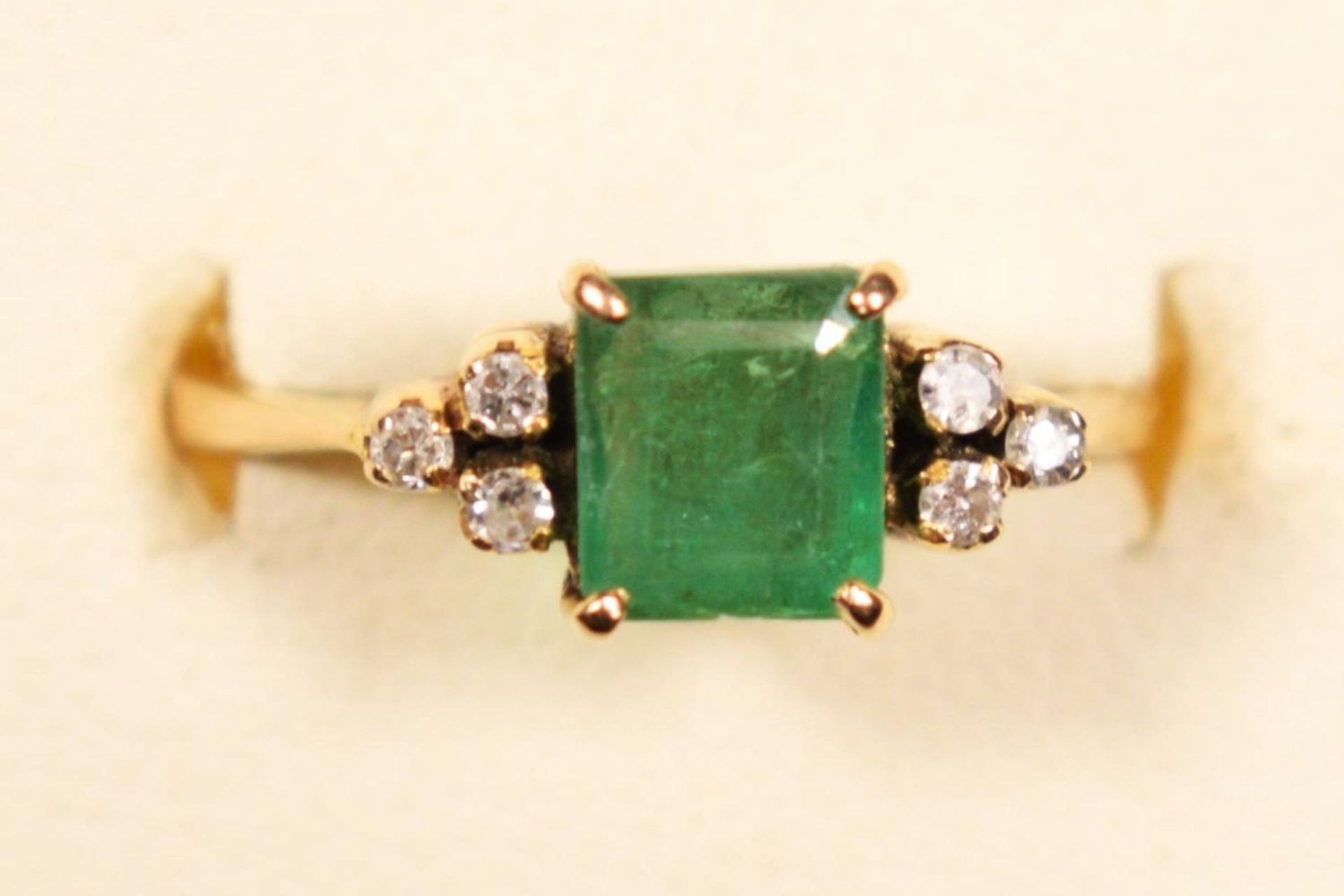 A 14K gold emerald and diamond ring, claw set with an emerald cut stone, 6 x 5mm flanked by single - Image 2 of 3