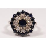 An 18ct white gold sapphire and diamond cluster ring, claw set with brilliant cut stones, diamond