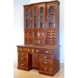A late 19th century mahogany housekeepers desk with upper inverted breakfront cabinet, having four