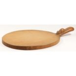 A Robert Mouseman Thompson of Kilburn, oval oak cheese board, with carved mouse trademark, 39cm.