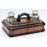 A late Victorian ebonised and walnut double inkstand, with two glass ink bottles, two pen trays