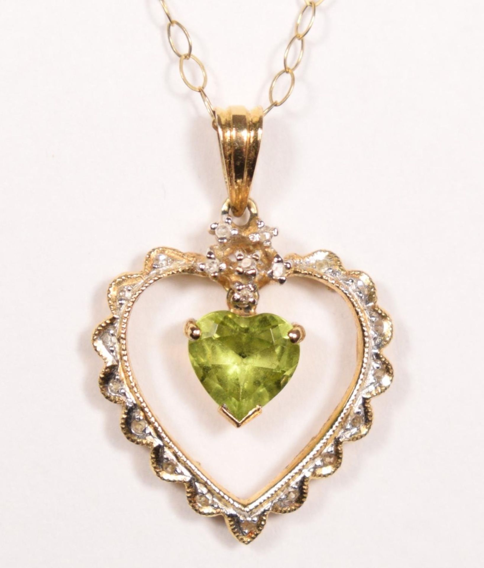 A 14k gold peridot and diamond pendant, claw set with an articulated stone, 24 mm overall, 9ct