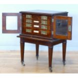 A 19th century oak campaign canteen of cutlery cabinet on stand, the glazed doors enclosing a bank