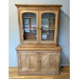 A Victorian pitch pine dresser, the upper section having two glazed doors opening to reveal three