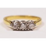 An 18ct gold three stone diamond ring, claw set with brilliant cut stones, London 1986, stated