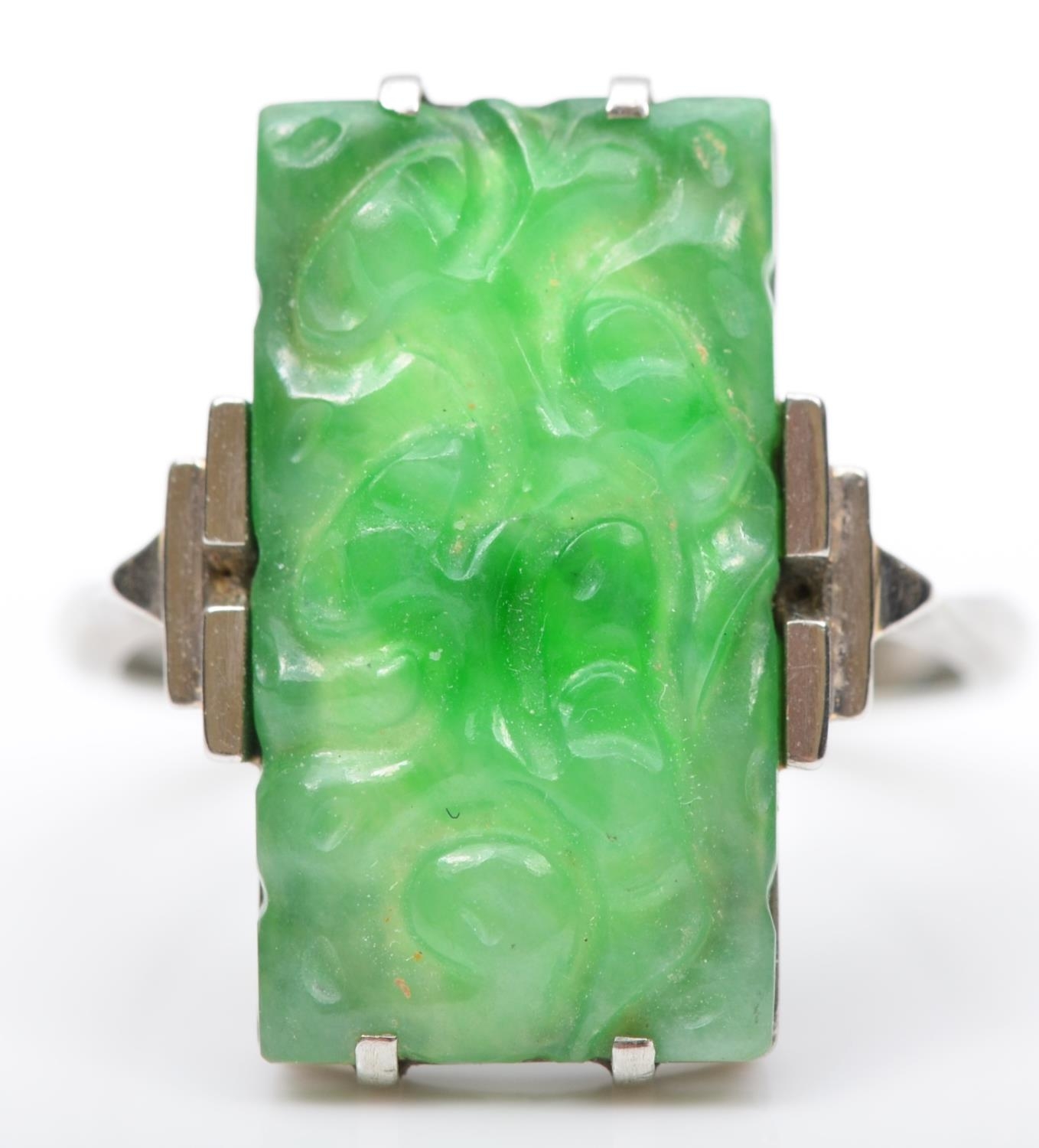 An Art Deco 9ct white gold and carved jadeite panel ring, 19 x 11mm, N, 3.7gm.