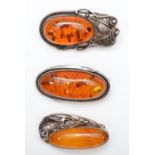 3 silver mounted amber brooches, 37g.