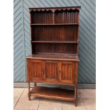 A early 20th century kitchen dresser, with a upper two shelf plate rack, above three hinged doors,