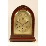 An early 20th century German Junghans mantel clock, mahogany case in archform, the silvered dial