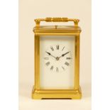 A brass 8 day repeater carriage clock, enamelled white dial with Roman numerals, the movement