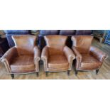 A set of three tan leather armchairs