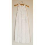 Two white christening gowns, one short sleeved with lace flower detailing around chest and at hem