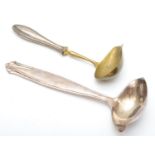 A white metal ladle, stamped 30 over J.R. and a 830 standard silver handled ladle