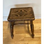 A Victorian oak stool, having carved decorated seat raised on spayed turned legs. H46cm W35cm.