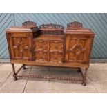 A early 20th century buffet, two central drawers flanked by hinged doors, opening to reveal a