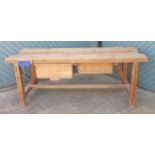 An industrial pitch pine workbench, mid 20th century, having a deep drawer on opposite sides with