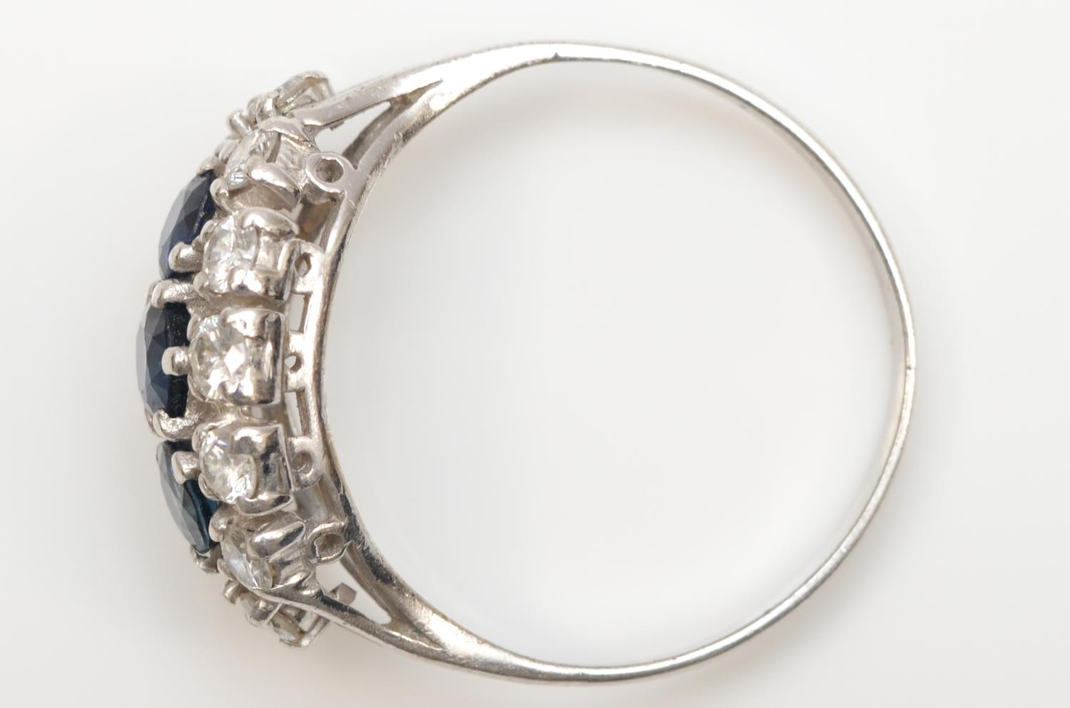 An unmarked 18ct white gold three sapphire and brilliant cut diamond cluster ring, diamond weight - Image 2 of 2