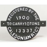 A round cast iron wagon plate, 'Caledonian Ry. Co. 1900, To Carry 10 Tons No. 13337'.