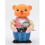 A tinplate toy of a bear taking photos, tinplate body with fabric arms and rubber hear, on winding