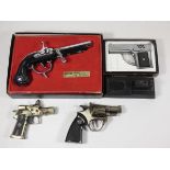 A collection of novelty gas cigarette lighters, in the form of pistols, table and pocket examples.