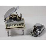 A 1950s figural petrol table cigarette lighter, in the form of a grand piano, pressing the keys