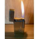 A Dunhill 70 pocket cigarette lighter, gold plated with bark effect decoration.