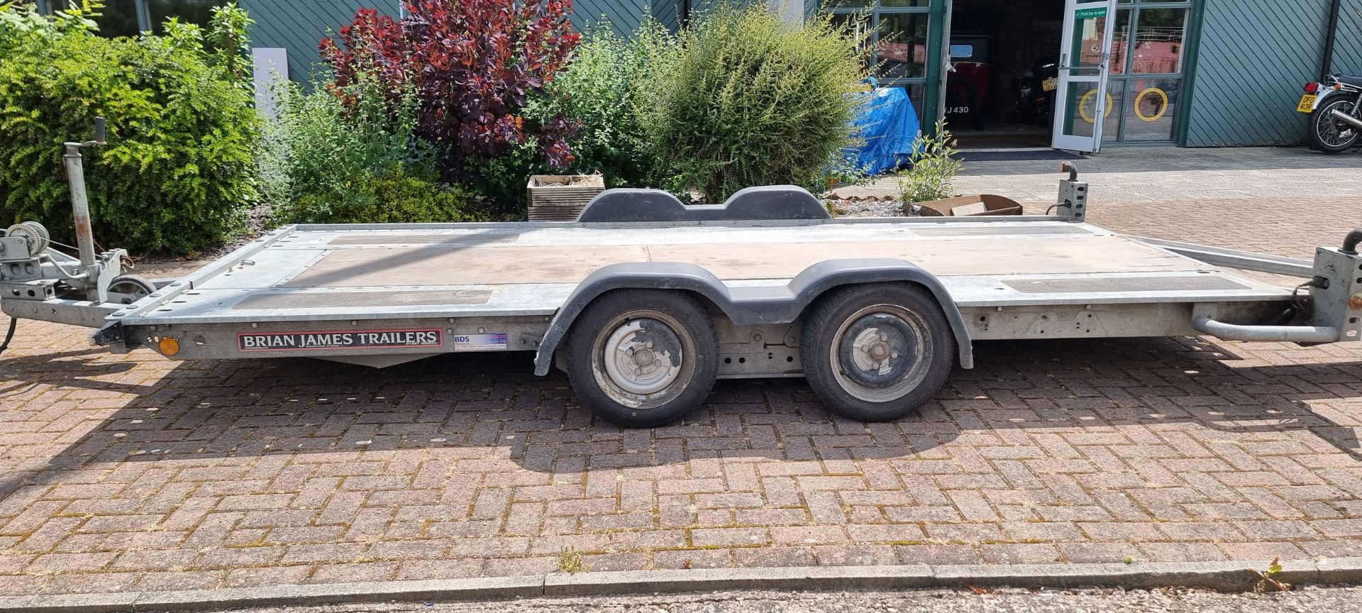 A Brian James twin axel car trailer, 1600kg load, with pull out ramps and locking tow hitch with