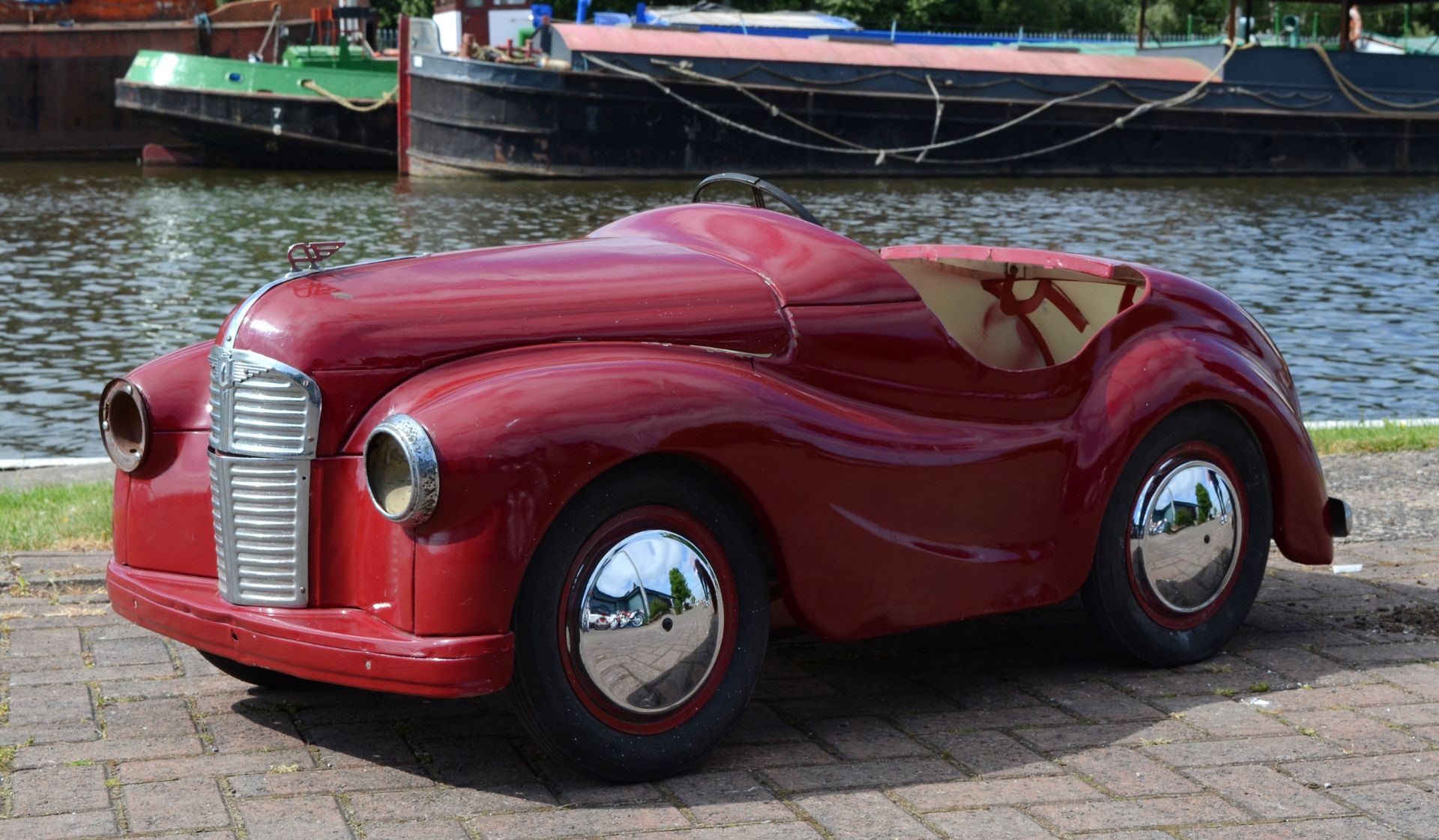 An Austin J40 pedal car, c.1948, offered in red, partially restored. The car was made from heavy-