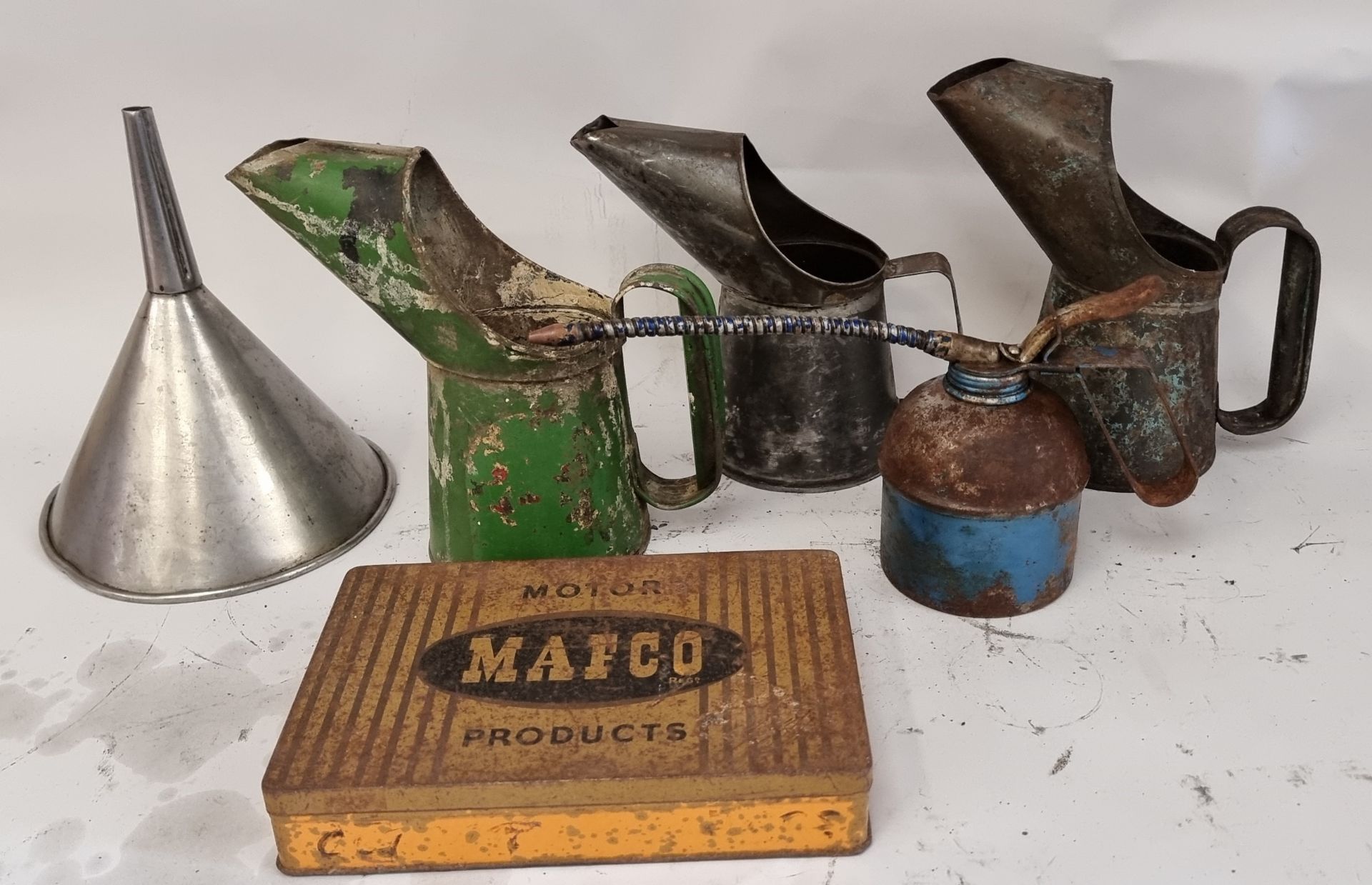 A Mafco Motor Products tin, three oil pourers a hand oil pump and a funnel