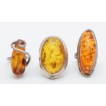 Three silver and amber dress rings, 32gm