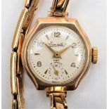 A 9ct gold Everite ladies manual wind wristwatch, to a metal core bracelet