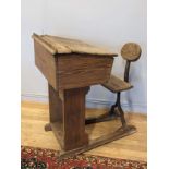 A late 19th / early 20th century pine school desk, with hinged desktop, ink hole and attached chair