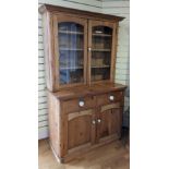 A pine kitchen dresser, glazed upper, hinged doors open to reveal three shelves, above two small
