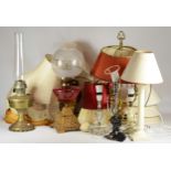 A large collection of table lamps, standard lamps with shades, together with two oil lamps.