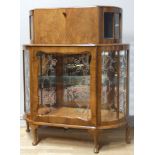 A 1960's drinks cabinet, walnut veneered, upper hinged door over a glazed unit with sliding glass