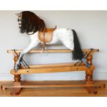 A child's rocking horse, composite body with horse hair tail and mane, leather tac and saddle, metal