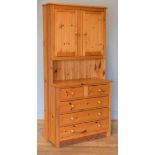 A stained pine dresser, two hinged doors open to reveal a shelved interior, over two small drawers