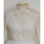 A cream lace vintage wedding dress with veil and pearlised floral and bead circlet headdress. The