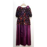 A ladies ball gown with a full purple floor length skirt with a puff sleeved top in an abstract