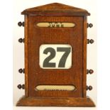 An Edwardian oak perpetual desk calendar, displaying month, date and day, 28cm tall