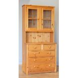 A pine dresser, two hinged lead fronted glazed doors open to reveal a shelved interior, over two