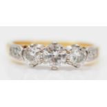 An 18ct gold three stone diamond ring, London 1976, claw set with brilliant cut stones,
