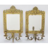 A pair of early 20th century of brass girandole bevelled glass mirrors, with pierced and cast